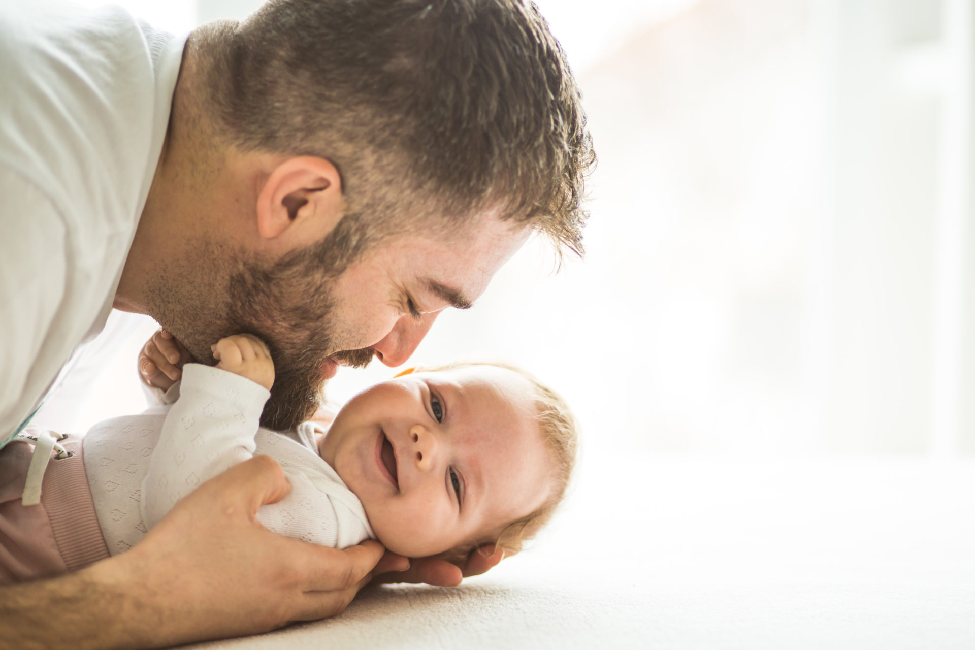 Happy mature father playing with his baby daughter (3 months old). 